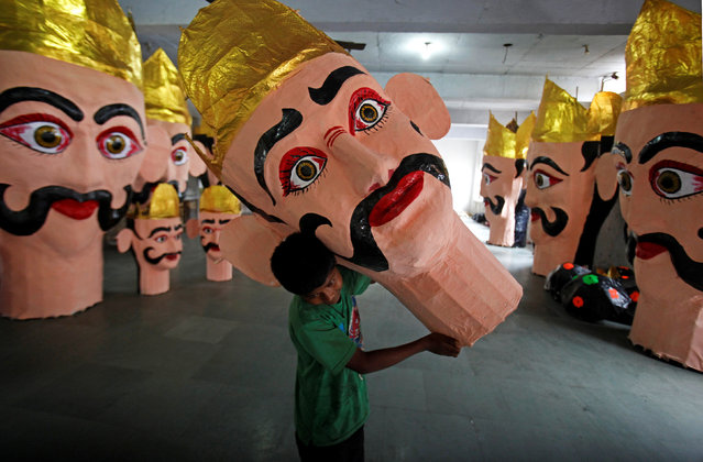 A boy carries the head of an effigy of demon king Ravana during preparations for the upcoming Hindu festival of Dussehra, in Chandigarh, India September 23, 2017. (Photo by Ajay Verma/Reuters)