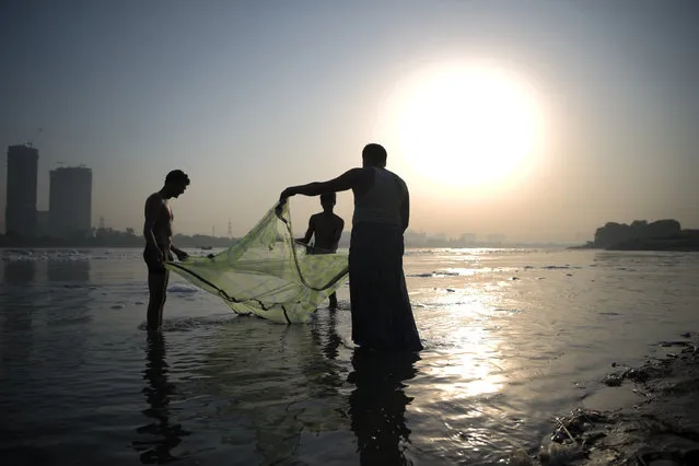 Fishermen fling fishing net into the torpid waters of the Yamuna on October 03, 2017 in New Delhi, India. Yamuna river is increasingly becoming unliveable with dirty and toxic water for an aquatic life it once supported easily. Catching fishes in Yamuna within Delhi is rare as the river is polluted to the extent that no aquatic life is left in it. Men enjoy the heavy flow of water which brings with it fishes that are otherwise rare. (Photo by Shams Qari/Barcroft Imagesages)
