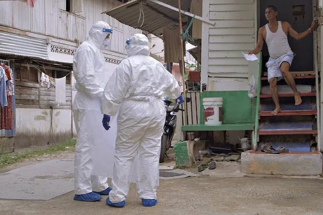 Government health workers conduct checks on a migrant man on May 6, 2020 in Kuala Lumpur, Malaysia. Malaysian authorities has been condemned by United Nation (UN) as they arrested hundreds of undocumented migrants this week amid rise in xenophobia. UN urges Malaysia to avoid detaining migrants and release all their children and caregivers, warning that overcrowded detention centres carried a high risk of spreading the Covid-19. (Photo by Rahman Roslan/Getty Images)