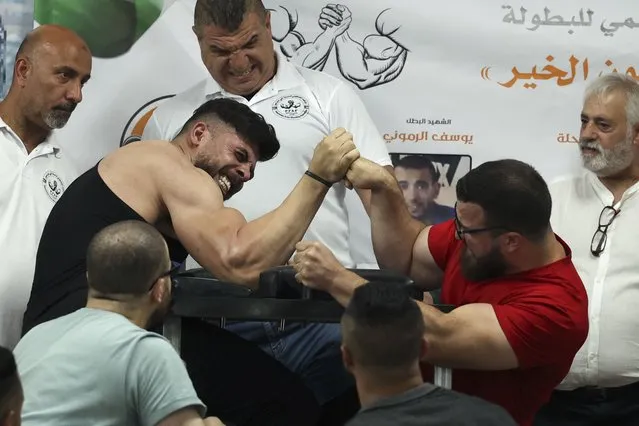 Palestinians take part in a two-day arm wrestling championship in Rammun village, east of Ramallah, in the West Bank on September 9, 2022. (Photo by Abbas Momani/AFP Photo)