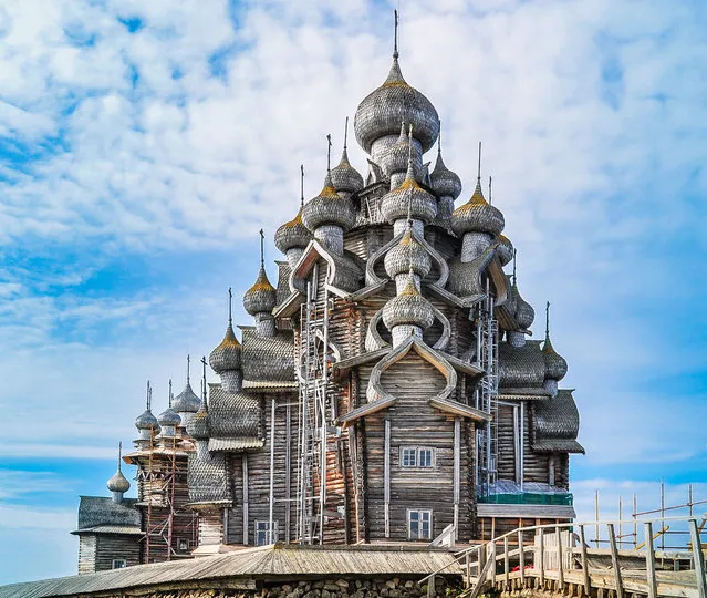 Built in the early 18th century, Russia’s Church of the Transfiguration features an octagonal spruce and pine log framework with 22 domes covered with birch bark. Construction of the wooden structure began in 1714, and it is said to have been built without a single nail. (Photo by jejim via Getty Images )