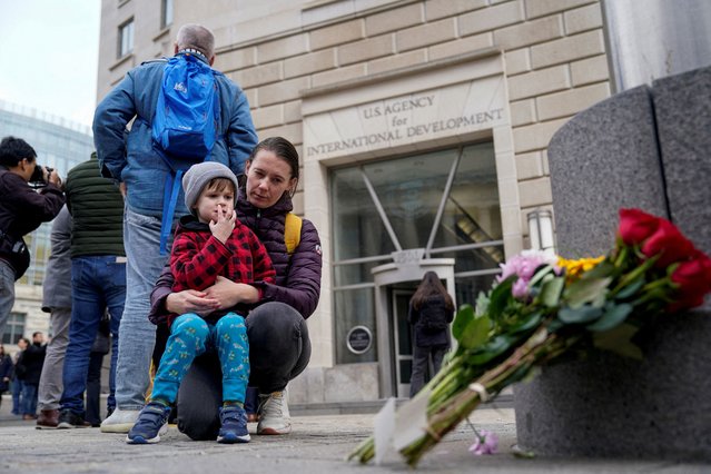 People stand outside the USAID building, as it sits closed to employees after a memo was issued advising agency personnel to work remotely, in Washington, on February 3, 2025. (Photo by Kent Nishimura/Reuters)