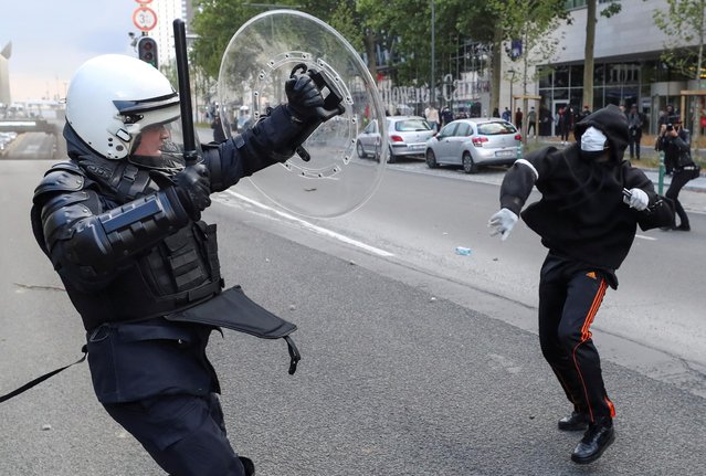 A demonstrator throws an object towards a police officer during a protest, organised by Black Lives Matter Belgium, against racial inequality in the aftermath of the death in Minneapolis police custody of George Floyd, in central Brussels, Belgium on June 7, 2020. (Photo by Yves Herman/Reuters)