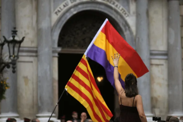 A pro Independence demonstrator holds up four fingers symbolizing the four stripes of the Catalonian flag during a demonstration outside the regional presidential palace in Sant Jaume Square in Barcelona, Spain, Thursday, November 2, 2017. Spain's National Court in Madrid was questioning ousted Catalan government members Thursday in an investigation into possible rebellion charges for having declared the region's independence, while a parallel Supreme Court session for six Catalan lawmakers was suspended for a week. (Photo by Manu Fernandez/AP Photo)