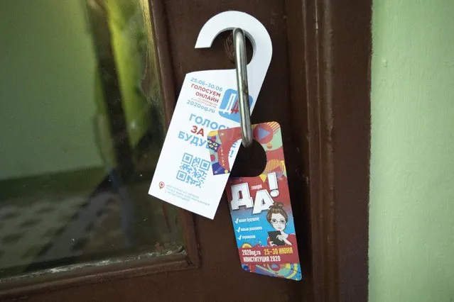 In this photo taken on Friday, June 19, 2020, a leaflet advertising for a new constitution reading “Vote for the future. Say Yes” is seen on a door handle in an apartment building in Moscow, Russia. Russian authorities seem to be pulling out all the stops to get people to vote on constitutional amendments that would enable President Vladimir Putin to stay in office until 2036. (Photo by Alexander Zemlianichenko/AP Photo)