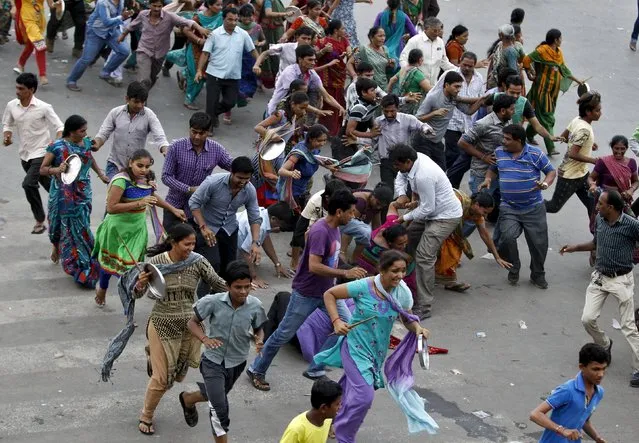 Members of the Patel community run as they are dispersed by Indian police during a protest rally in Ahmedabad, India, September 19, 2015. Thousands of the community members on Saturday protested against the detention of Hardik Patel, who is leading the movement to demand reservation benefits for the community, local media reported. (Photo by Amit Dave/Reuters)