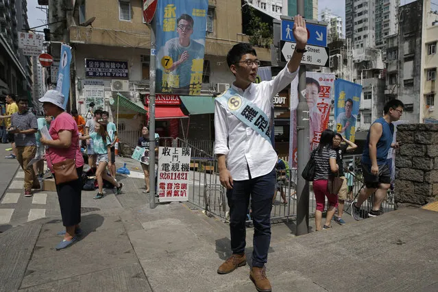 Hong Kong election candidate Nathan Law of the new political party Demosisto waves in Hong Kong, Sunday, September 4, 2016. Polls opened in Hong Kong Sunday for the specially administered Chinese city's most crucial election since the handover from Britain in 1997. The vote for lawmakers in the Legislative Council is also the first since 2014 pro-democracy street protests rocked the Asian financial hub. (Photo by Kin Cheung/AP Photo)