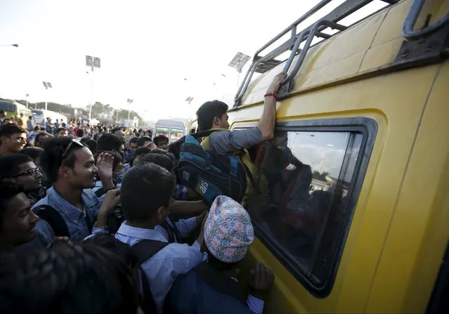 A passenger (C) climbs through the window of an overcrowded bus as limited public transportation operates in the city during the ongoing fuel crisis in Kathmandu, Nepal October 9, 2015. (Photo by Navesh Chitrakar/Reuters)