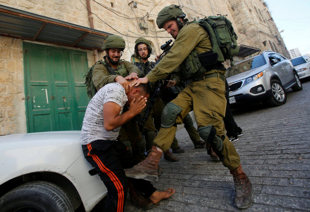 Israeli soldiers detain a Palestinian during a searching raid by Israeli troops, in the West Bank city of Hebron September 20, 2016. (Photo by Mussa Qawasma/Reuters)