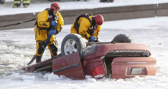 Kansas City fire department rescue workers work to recover a minivan that went into Brush Creek in Kansas City, Mo., on Thursday, December 22, 2022. Police say the driver lost control of the minivan on an icy street and the vehicle went down an embankment and overturned before submerging in Brush Creek. The driver was pulled from the creek but died later at a hospital. (Photo by Nick Wagner/The Kansas City Star via AP Photo)