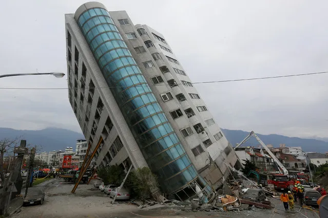 Rescue workers are seen by a damaged building after an earthquake hit Hualien, Taiwan February 7, 2018. (Photo by Reuters/Stringer)