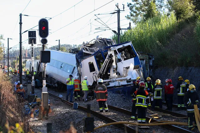 Firefighters and technicians inspect the wreckage after a train derailed upon a collision with a work machine, in Soure, Coimbra, center of Portugal, 31 July 2020. According to reports 72 vehicles with 181 operational and and two planes are being mobilized for the crash site after a train derailed after a collision with maintenance machine leaving at least one person dead and about 50 other passengers injured. (Photo by Paulo Cunha/EPA/EFE)