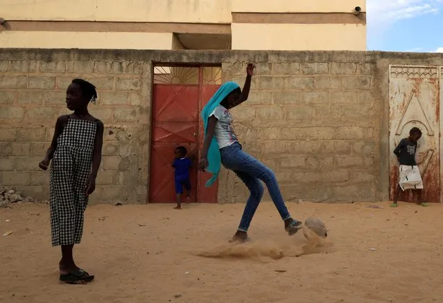 Maty Diop plays soccer outside her house, on the outskirts of Dakar, Senegal on January 17, 2023. (Photo by Zohra Bensemra/Reuters)