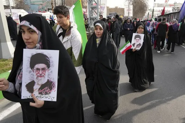 Iranian demonstrators carry posters of the Supreme Leader Ayatollah Ali Khamenei and their national flag during the annual rally commemorating Iran's 1979 Islamic Revolution, in Tehran, Iran, Saturday, February 11, 2023. Iran on Saturday celebrated the 44th anniversary of the 1979 Islamic Revolution amid nationwide anti-government protests and heightened tensions with the West. (Photo by Vahid Salemi/AP Photo)