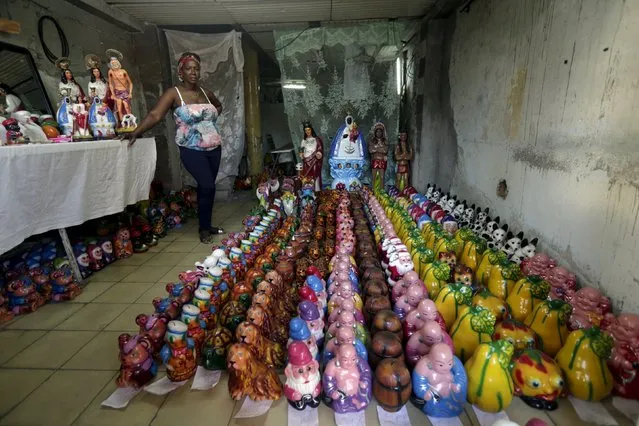 Himisis, 51, stands near piggybanks and religious statues for sale, in her house in Havana October 26, 2015. (Photo by Enrique De La Osa/Reuters)