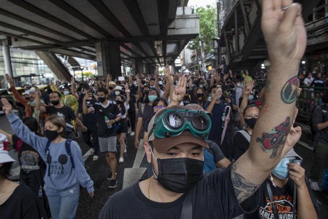 Pro-democracy protesters flash three-fingered salute during a protest in Udom Suk, suburbs of Bangkok, Thailand, Saturday, October 17, 2020. (Photo by Gemunu Amarasinghe/AP Photo)