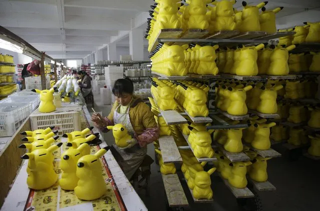 A worker paints money boxes in the shape of cartoon character Pikachu at a pottery factory in Dehua, Fujian province December 7, 2014. (Photo by Reuters/Stringer)