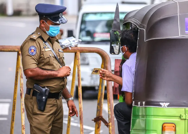 Sri Lankan police officers check vehicles in a checkpoint during a quarantine curfew, as a preventive measure against the spread of the COVID-19 in Colombo on October 25, 2020. (Photo by Saman Abesiriwardana/Pacific Press/LightRocket via Getty Images)