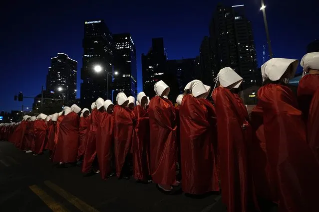 Israeli women's rights activists dressed as characters in the popular television series, “The Handmaid's Tale”, protest plans by Prime Minister Benjamin Netanyahu's government to overhaul the judicial system, in Tel Aviv, Israel, Saturday, March 11, 2023. (Photo by Ohad Zwigenberg/AP Photo)