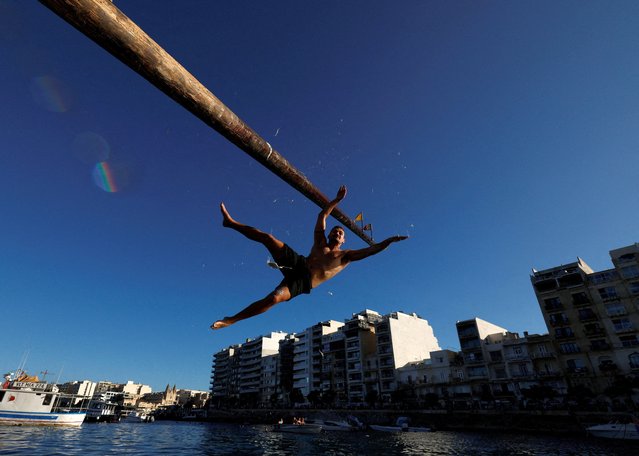 A competitor falls off the “gostra”, a wooden pole covered in lard, during the celebrations for the religious feast of St Julian, patron of the town of St Julian's, Malta, on August 31, 2025. (Photo by Darrin Zammit Lupi/Reuters)