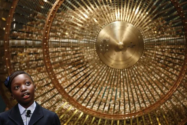 A schoolgirl stands next to a lottery drum during the draw for Spain's Christmas Lottery “El Gordo” in Madrid December 22, 2014. The total prize money of 2.4 billion euros is split into thousands of cash prizes amongst hundreds of winning numbers. (Photo by Juan Medina/Reuters)
