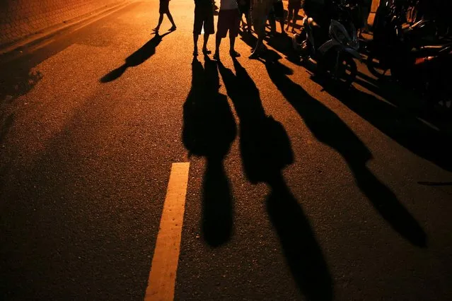 Onlookers gather at the site where a man was killed in a shootout with police in Manila, Philippines early October 21, 2016. (Photo by Damir Sagolj/Reuters)