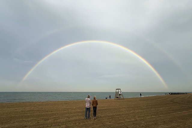 People look at a double rainbow over Lake Michigan, Wednesday, June 4, 2025, in Chicago. (Photo by Kiichiro Sato/AP Photo)
