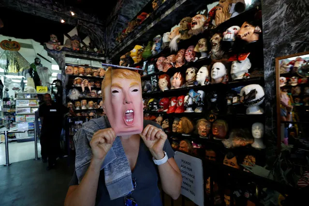 A person tries on a mask depicting Republican presidential nominee Donald Trump at Hollywood Toys & Costumes in Los Angeles, California U.S., October 26, 2016. (Photo by Mario Anzuoni/Reuters)