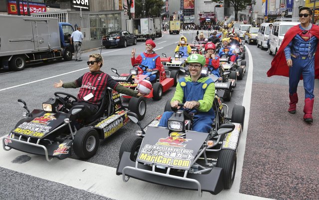 People dressed in costumes as Super Mario, super heroes and others drive custom built Go-Karts through a street in Tokyo's Shibuya shopping district Saturday, October 29, 2016. With a Japanese or international driver's license, you can enjoy two or three-hour Tokyo tour at 8,000 yen (US84 dollars) or 11,000 yen ($116) respectively, including the costume rental fee. (Photo by Koji Sasahara/AP Photo)