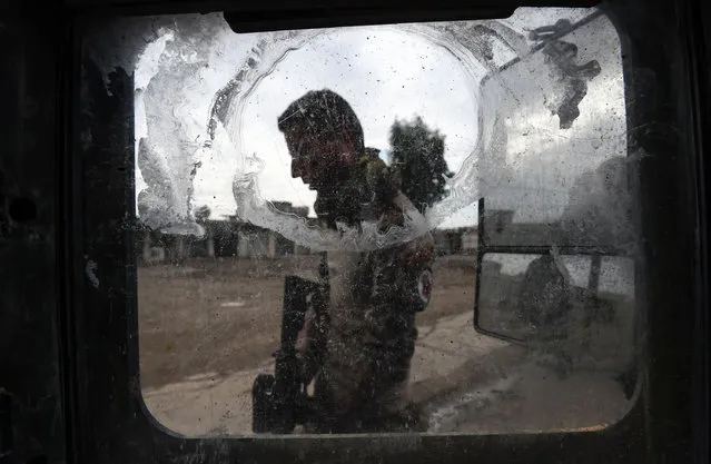 An Iraqi soldier takes position in the village of Gogjali, a few hundred metres of Mosul's eastern edge, as clashes go on between Iraqi army forces and jihadists of the Islamic State (IS) group to retake Mosul, the last Iraqi city under the control of IS, on November 2, 2016. More than a million civilians in Mosul were in grave danger and aid workers were “bracing for the worst”, a relief group said, after Iraqi forces reached the jihadist-held city. (Photo by Bulent Kilic/AFP Photo)
