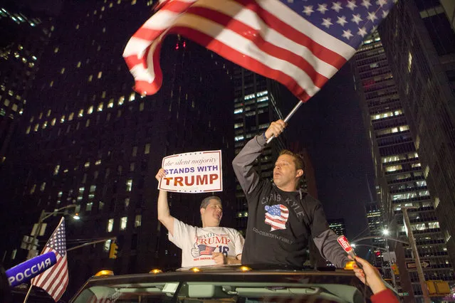 Donald Trump supporters ride down 6th Avenue with a US flag in New York, USA, 09 November 2016. (Photo by Alessandro Vecchi/AFP Photo/DPA)