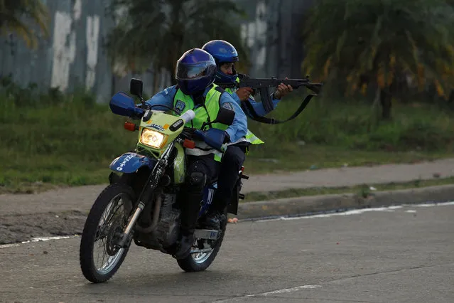 A police officer aims his weapon towards students (not pictured) during a protest against the re-election of Honduran President Juan Orlando Hernandez in the 2017 election, in Tegucigalpa, Honduras, November 9, 2016. (Photo by Jorge Cabrera/Reuters)