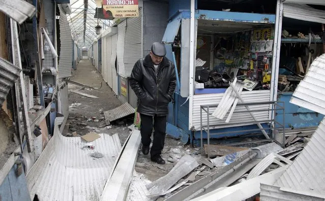 A man walks past a shop which was recently damaged by shelling, at a local market in Donetsk, eastern Ukraine, January 29, 2015. (Photo by Alexander Ermochenko/Reuters)