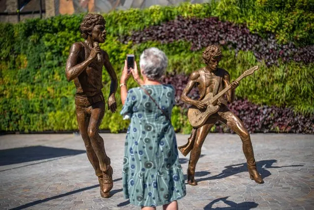 A woman photographs statues of Rolling Stones musicians Mick Jagger and Keith Richards on August 10, 2023 in Dartford, England. On August 9, Dartford unveiled bronze statues by artist Amy Goodman commemorating rock legends Mick Jagger and Keith Richards, who met as teenagers at the town's train station in 1961, and formed The Rolling Stones a year later. (Photo by Carl Court/Getty Images)