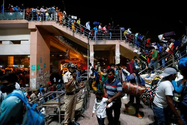 Migrant workers arrive at a bus station to board buses to return to their villages after Delhi government ordered a six-day lockdown to limit the spread of the coronavirus disease (COVID-19), in Ghaziabad on the outskirts of New Delhi, India, April 19, 2021. (Photo by Adnan Abidi/Reuters)