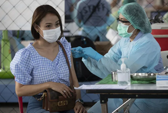 A health worker administers a dose of the Sinovac COVID-19 vaccine to a person working at an entertainment venue where a new cluster of COVID-19 infections was found, in Bangkok, Thailand, Wednesday, April 7, 2021. (Photo by Sakchai Lalit/AP Photo)