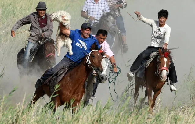 Participants ride horses as they compete for a goat carcass during a Buzkashi game in Bayingol, Xinjiang Uighur Autonomous Region, China September 6, 2018. (Photo by Reuters/China Stringer Network)