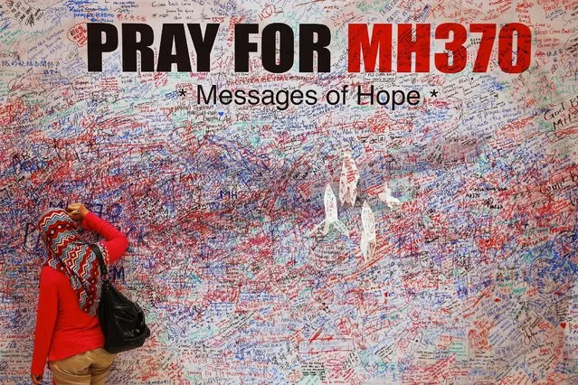 A woman leaves a message of support and hope for the passengers of the missing Malaysia Airlines MH370 in central Kuala Lumpur in this March 16, 2014 file photo.  A piece of suspected plane wreckage has been found off the coast of southern Thailand, a local official said on January 23, 2016, prompting speculation it might belong to Malaysia Airlines Flight MH370, which vanished nearly two years ago. (Photo by Damir Sagolj/Reuters)
