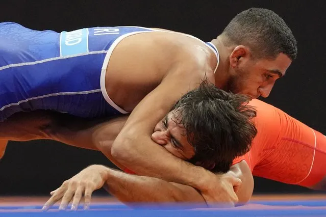 Iran's Rahman Amouzadkhalili, top, and India's Bajrang compete during the Men's Freestyle 65Kg wrestling semifinal Asian Games in Hangzhou, China, Friday, October 6, 2023. (Photo by Aaron Favila/AP Photo)