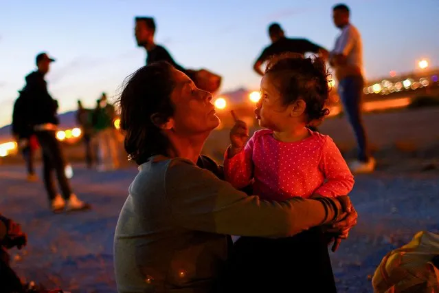 Maria Gonzalez, a Venezuelan migrant seeking asylum in the United States, sits with her 2-year-old granddaughter, Edith, on the banks of the Rio Bravo river, as the Texas National Guard block the crossing at the border between the U.S. and Mexico, in Ciudad Juarez, Mexico on October 5, 2023. (Photo by Jose Luis Gonzalez/Reuters)