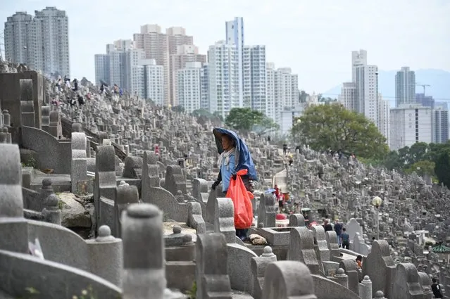 A workers cleans the graves in a cemetery in Diamond Hill in Hong Kong on October 23, 2023, during the Chung Yeung Festival, also known as the Double Ninth Festival, where people honour their ancestors. (Photo by Peter Parks/AFP Photo)