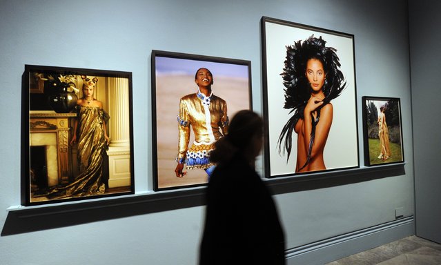 A woman walks by framed photos at the press preview for “Vogue 100: A Century of Style” exhibiting the photographs that has been commissioned by British Vogue since it was founded in 1916 at National Portrait Gallery on February 10, 2016 in London, England. (Photo by Stuart C. Wilson/Getty Images)