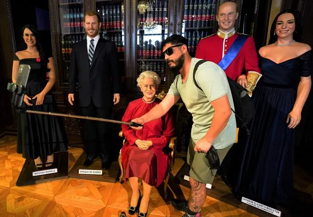 A visitor takes a selfie with the wax figure of Queen Elizabeth II and other royal family members, at the wax museum in Mexico City, Thursday, September 8, 2022. Queen Elizabeth II, Britain's longest-reigning monarch, died Thursday after 70 years on the throne. She was 96. (Photo by Fernando Llano/AP Photo)