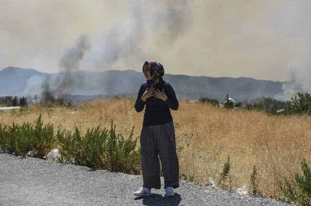 A woman looks at the wildfires in Kacarlar village near the Mediterranean coastal town of Manavgat, Antalya, Turkey, Saturday, July 31, 2021. (Photo by AP Photo/Stringer)