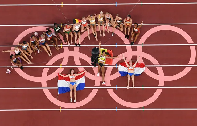 An overview shows Gold medallist Belgium's Nafissatou Thiam (C), silver medallist Netherlands' Anouk Vetter (R) and bronze medallist Netherlands' Emma Oosterwegel as they pose after the women's heptathlon event during the Tokyo 2020 Olympic Games at the Olympic Stadium in Tokyo on August 5, 2021. (Photo by Antonin Thuillier/AFP Photo)