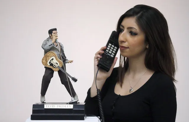 A Sotheby's employee holds an Elvis Presley telephone that is on display at the auction house in London, Friday, February 26, 2016. Over 500 items of the personal collection of Deborah, Duchess of Devonshire's private collection  are shown ahead of Sotheby's public exhibition and sale. (Photo by Frank Augstein/AP Photo)