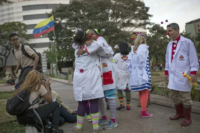 Clowns from the volunteer group Doctor Yaso gather during the celebration of their 14th anniversary, in Caracas, Venezuela, Thursday, February 7, 2019. Trucks carrying U.S. humanitarian aid destined for Venezuela arrived Thursday at the Colombian border, where opposition leaders vowed to bring them into their troubled nation despite objections from embattled President Nicolas Maduro. (Photo by Rodrigo Abd/AP Photo)