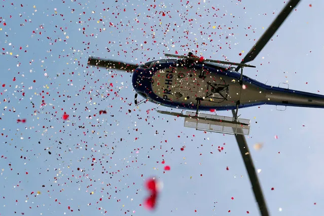 A helicopter showers flowers in honor of victims of the collapse of a dam owned by Brazilian mining company Vale SA, in Brumadinho, Brazil February 25, 2019. (Photo by Washington Alves/Reuters)