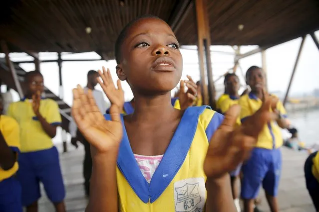A girl sings during morning devotion before the start of classes at a floating school in the Makoko fishing community on the Lagos Lagoon, Nigeria February 29, 2016. (Photo by Akintunde Akinleye/Reuters)