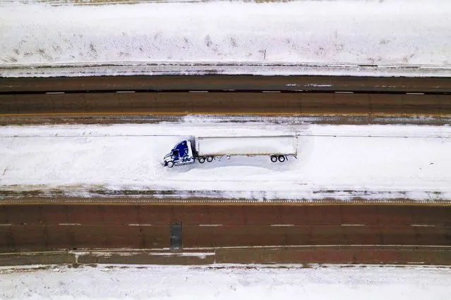A semi-trailer truck lies overturned and stranded amid sub-zero temperatures, ahead of the Iowa state caucus vote, near Van Meter, Iowa, on January 15, 2024. (Photo by Cheney Orr/Reuters)